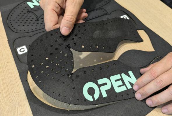 Hands stitching an Open Barefoot shoe upper with two needles